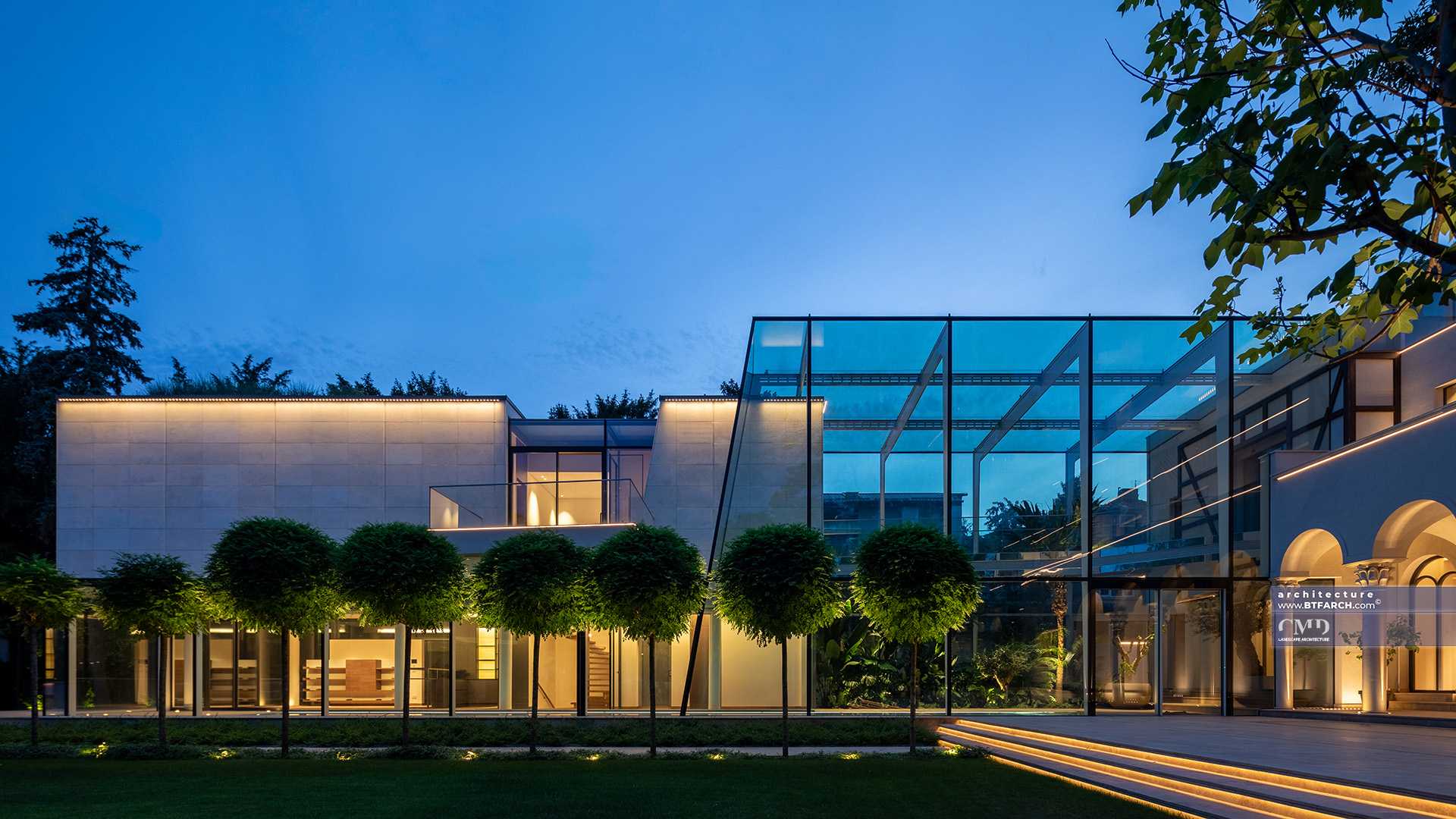 Classic garden project featuring architectural lighting on a modern glass extension at dusk