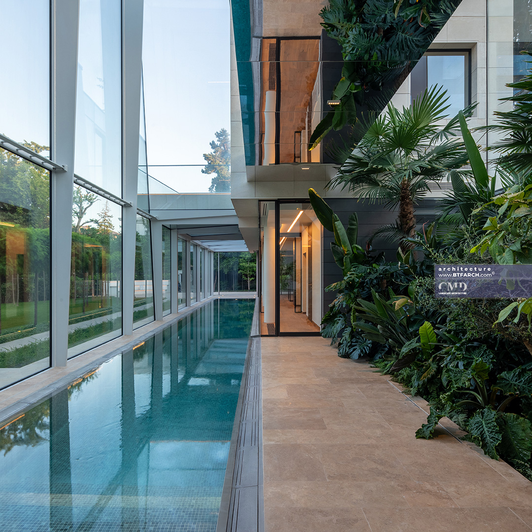 Indoor pool surrounded by lush exotic plants in a glasshouse, part of a classic garden project